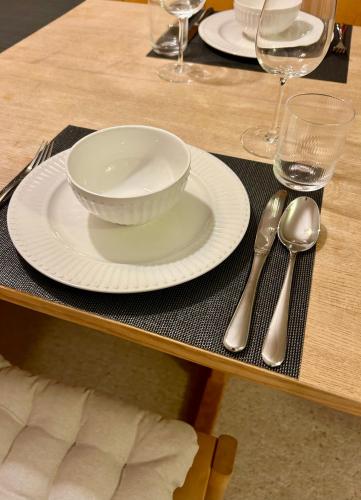 a table with a white plate and silverware on it at Cosy studio apartment in Splügen in Splügen