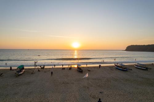 a group of people on a beach at sunset at Sea Star Resort in Agonda
