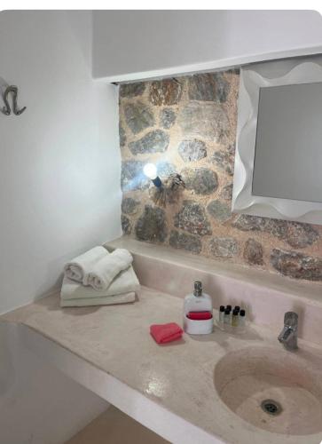 a bathroom sink with towels and a mirror at Sakas Residences in Karterados