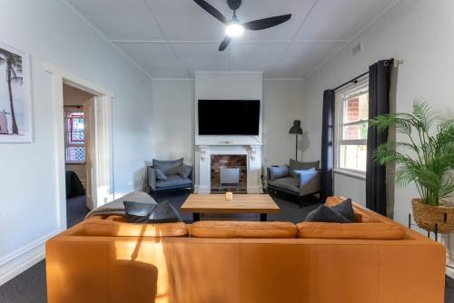 a living room with a couch and a tv at Summers Cottage - Port Noarlunga in Port Noarlunga
