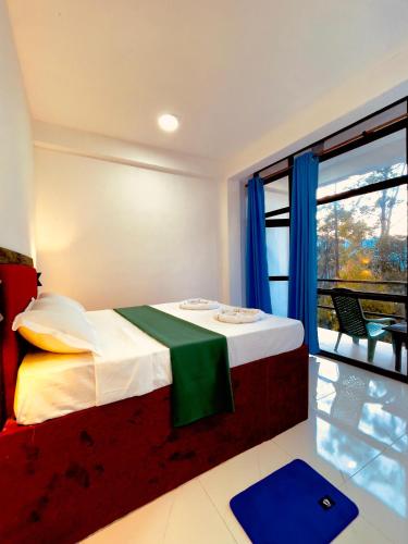 a bedroom with a bed and a large window at Cozy forest ella in Ella