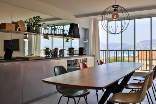 une cuisine et une salle à manger avec une table et des chaises dans l'établissement FRIDA by Home Saint Tropez, à Saint-Tropez