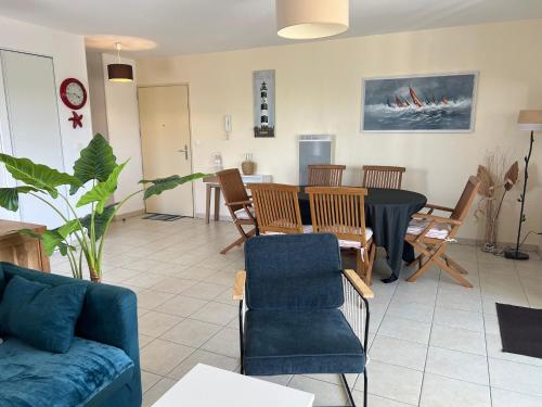 un salon avec une table et des chaises de salle à manger dans l'établissement Appartement moderne 3 pièces avec balcon, ascenseur, proche plages et commerces, parking inclus - FR-1-349-64, à Ploemeur