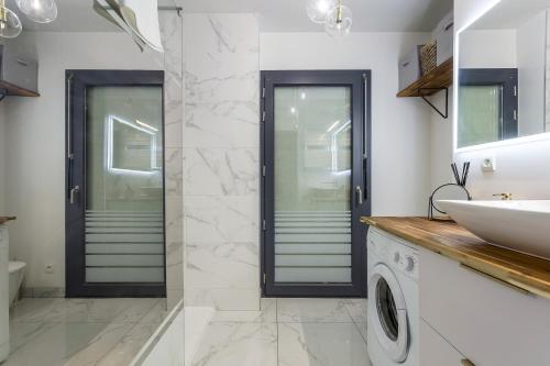 une salle de bain avec un lavabo et une machine à laver dans l'établissement SmartStay Boheme - Confluence, à Lyon