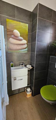 a bathroom with a sink and a painting on the wall at Chambre Gaëlle et Brian in Cardet