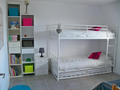 a bedroom with two bunk beds and a book shelf at Appartement T3 avec Terrasse à 30m des Commerces et Plage à Ploemeur - FR-1-349-72 in Ploemeur