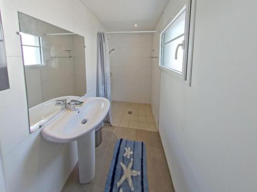 une salle de bain avec un lavabo et un miroir dans l'établissement Maison T3 moderne à 50m de la plage – Larmor-Plage - FR-1-349-126, à Larmor-Plage