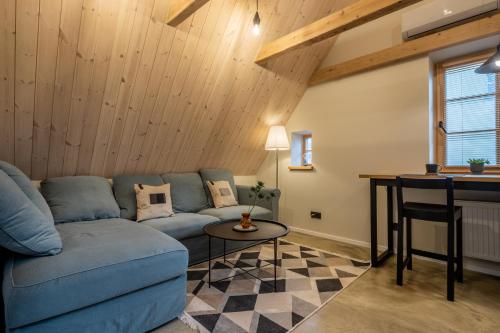 a living room with a blue couch and a table at B2 Apartments in Klaipėda
