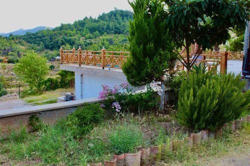 a bridge over a garden with trees and bushes at The Vista Village in Kumluca