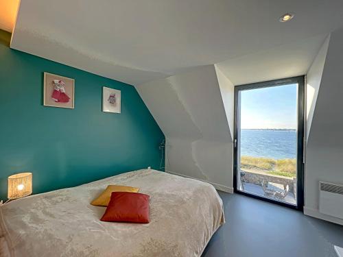 a bedroom with a bed and a large window at Maisonnette avec accès plage direct, 4/5 couchages, wifi - Gâvres - FR-1-349-117 in Gâvres