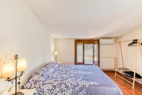 a bedroom with a bed with a blue bedspread at Cal Matalí in Espolla