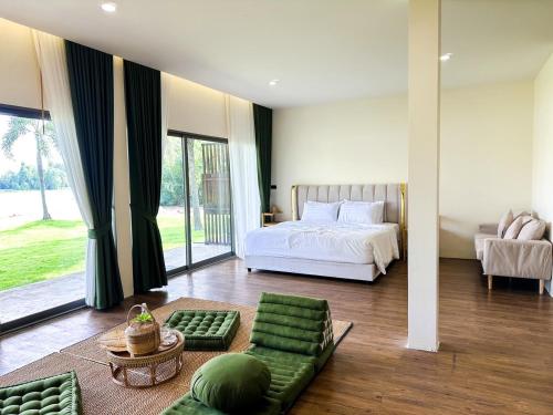 a bedroom with a bed and a large window at VAA chachoengsao in Ban Hua Sai