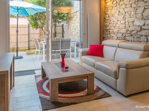 un salon avec un canapé et une table basse dans l'établissement Maisonette en pierre rénovée avec jardin à 100m de la plage - 5/6 couchages et Wi-Fi - FR-1-349-179, à Larmor-Plage