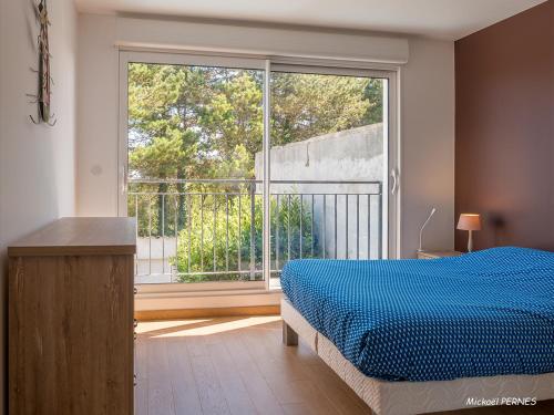une chambre avec un lit et une grande fenêtre dans l'établissement Maisonette en pierre rénovée avec jardin à 100m de la plage - 5/6 couchages et Wi-Fi - FR-1-349-179, à Larmor-Plage