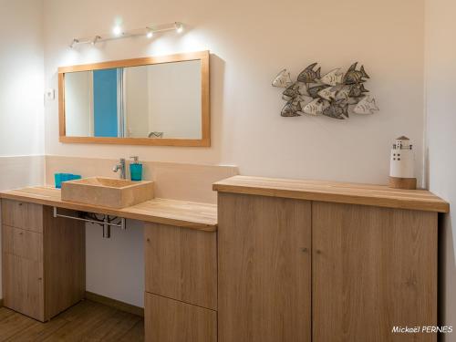 une salle de bain avec un lavabo et un miroir dans l'établissement Maisonette en pierre rénovée avec jardin à 100m de la plage - 5/6 couchages et Wi-Fi - FR-1-349-179, à Larmor-Plage