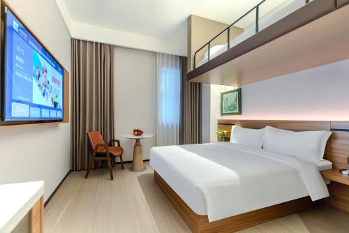 a hotel room with a large bed and a flat screen tv at 西安隐逸雅致酒店The Elegant Hotel- 南二环店South 2ndRing Road in Xi'an