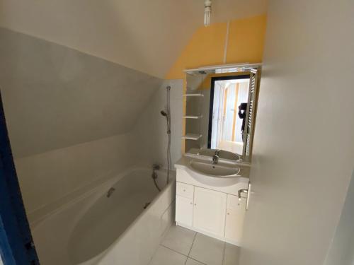 une salle de bain avec un lavabo, une baignoire et un miroir dans l'établissement Duplex T3 avec 2 parkings à 400m du centre de Lorient - FR-1-349-197, à Lorient