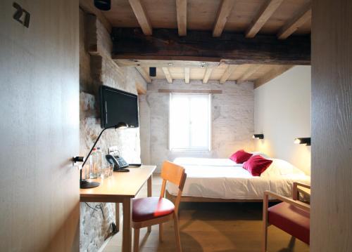 a bedroom with a bed and a table and a desk at 'S Hertogenmolens Hotel in Aarschot