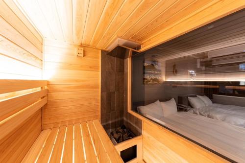 a small bed in a small room with wooden walls at RIVEIL Hakataekimae in Fukuoka