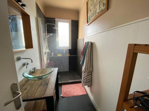 La salle de bains est pourvue d'un lavabo en verre et d'une douche. dans l'établissement Appartement T3 avec Terrasse, Proche Plage et Commerces à Larmor-Plage - FR-1-349-199, à Larmor-Plage