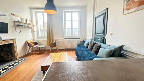 a living room with a blue couch and a fireplace at Le repère de la cathédrale - Metz Hypercentre in Metz