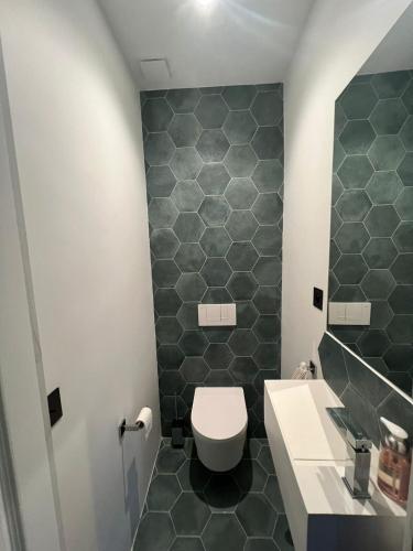 une salle de bain avec toilettes et lavabo dans l'établissement AppartHaussmann Paris Suresnes Longchamp, à Suresnes