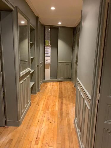 un couloir vide avec du parquet et une chambre avec des placards dans l'établissement AppartHaussmann Paris Suresnes Longchamp, à Suresnes
