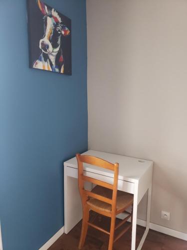 a chair next to a desk with a picture of a dog at Maison de campagne Le Bouchatel in Gourdon-Murat