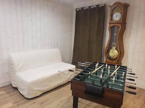a living room with a couch and a grandfather clock at Maison de campagne Le Bouchatel in Gourdon-Murat
