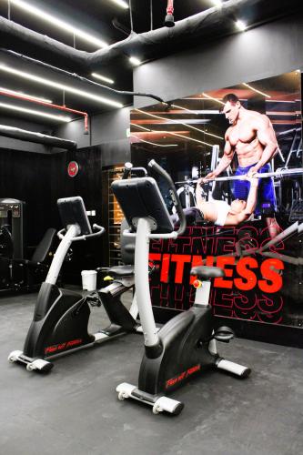 a gym with two exercise bikes and a man on a poster at City Tower Hotel in Fujairah