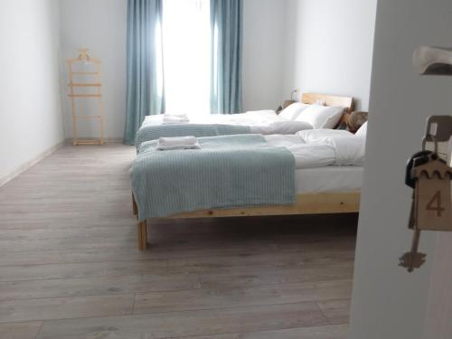 two beds in a room with wooden floors at Guesthouse Bacha & Lia in Mestia