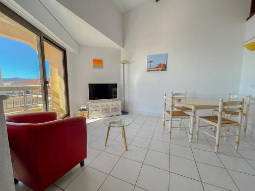 - un salon avec une table, des chaises et une télévision dans l'établissement Appartement vue mer et front de mer avec terrasse, à Fréjus