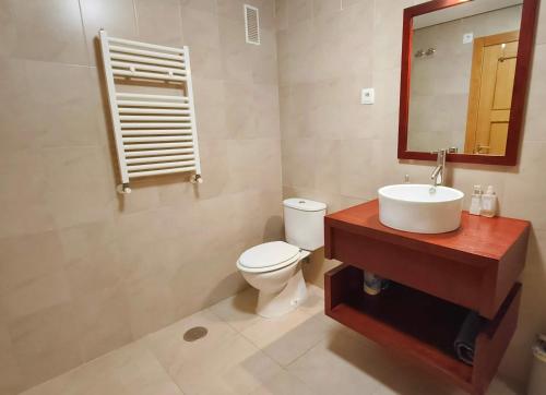 Un baño con inodoro, lavabo y espejo. en Bright Apartment with Stunning Swimming Pool Views - MO4812LT, en Torre-Pacheco