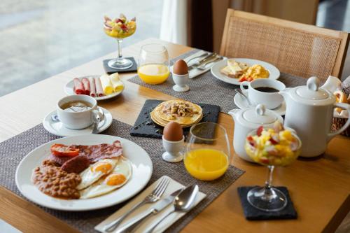 a table topped with plates of breakfast foods and drinks at Hotel da Graciosa in Santa Cruz da Graciosa