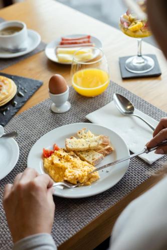 a person sitting at a table with a plate of breakfast food at Hotel da Graciosa in Santa Cruz da Graciosa