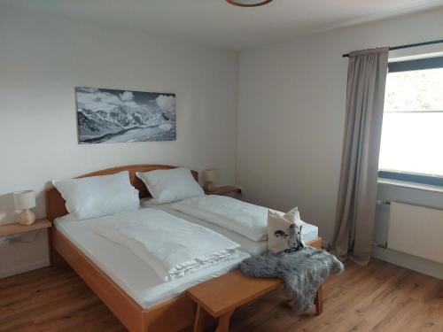 a bedroom with a bed with a table and a window at Ferienwohnung Stephanie im Landhotel Seeg in Seeg