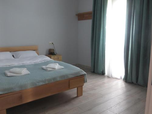 a bedroom with a bed with two towels on it at Guesthouse Bacha & Lia in Mestia