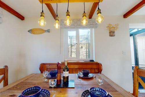 a dining room with a wooden table with wine glasses at Bryn Llys Uchaf in Capel-Curig
