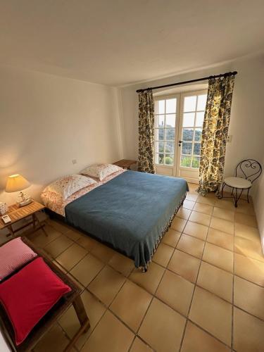 une chambre avec un lit et une grande fenêtre dans l'établissement Les îles bleues, à Rayol-Canadel-sur-Mer