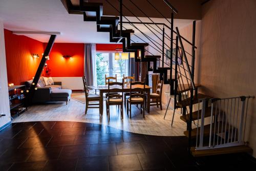a dining room with a table and chairs and a staircase at Landkulturhof Glücksbringer in Rudolstadt