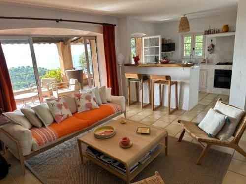 un salon avec un canapé orange et une cuisine dans l'établissement Les îles bleues, à Rayol-Canadel-sur-Mer