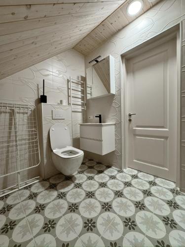 a bathroom with a toilet and a sink and a door at Independence square apartments II in Mažeikiai