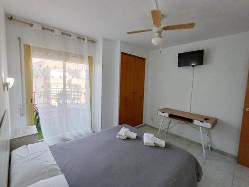 sypialnia z łóżkiem, stołem i telewizorem w obiekcie A H Rentals Carles III Apartamento 150mtrs playa w mieście Sant Carles de la Ràpita