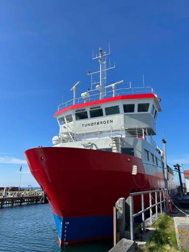 a red and white boat docked at a dock at Holiday home on Tunø - island of the year 2024 in Tunø