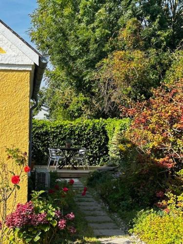 a garden with a table and chairs and flowers at Holiday home on Tunø - island of the year 2024 in Tunø