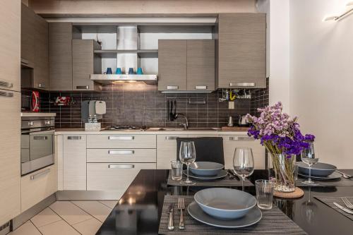 a kitchen with a table with plates and wine glasses at Barbudo's House in Lonato del Garda