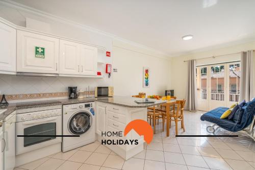 una cucina con armadi bianchi e una sala da pranzo con tavolo di #273 Pedra dos Bicos M by Home Holidays ad Albufeira