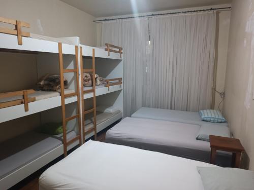 two bunk beds in a room with two beds at Assel Pousada Botanico in Curitiba