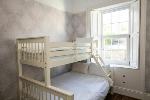 a bedroom with a bunk bed and a window at Beach Views Elegant & Modernised 5BD Period Home in Waterford