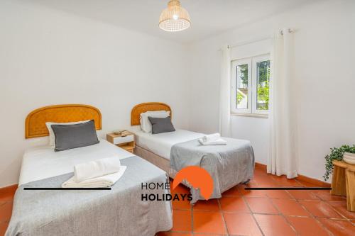 two beds in a room with a window at #250 Apartamento 264 by Home Holidays in Branqueira